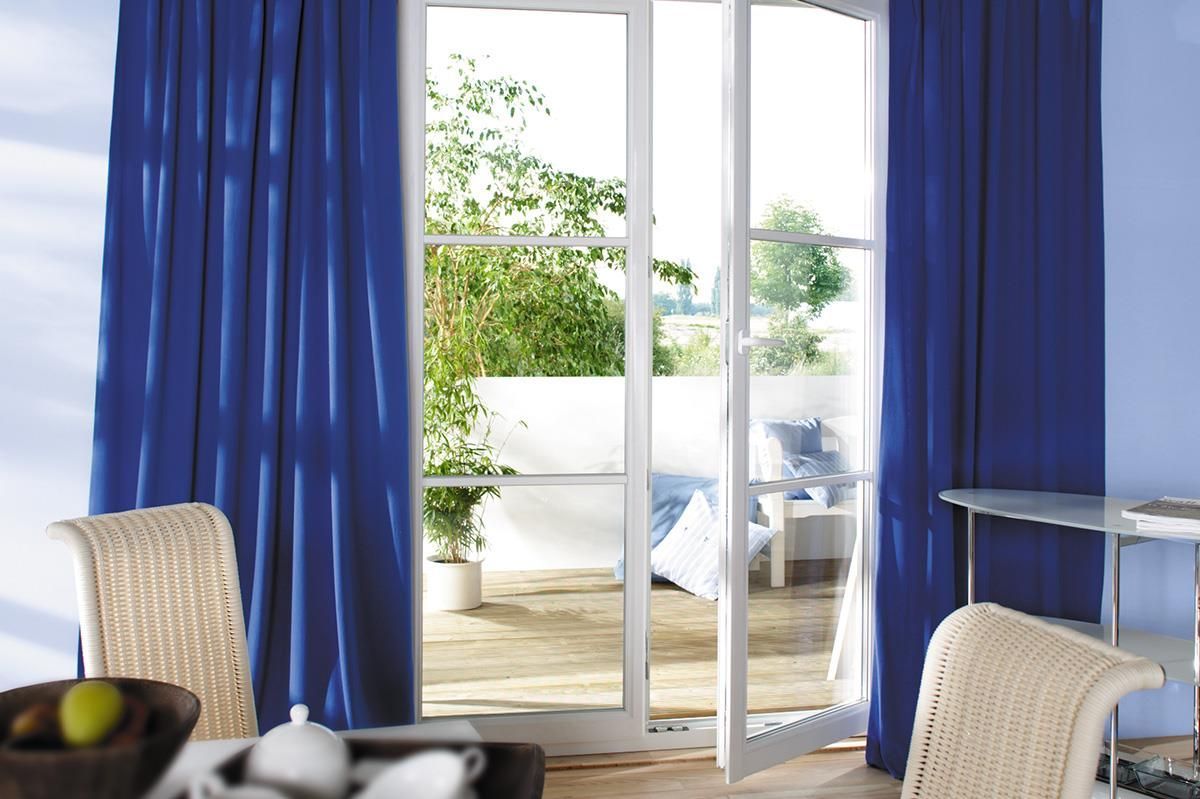 Ein Wohnzimmer mit blauen Vorhängen und einer Glasschiebetür