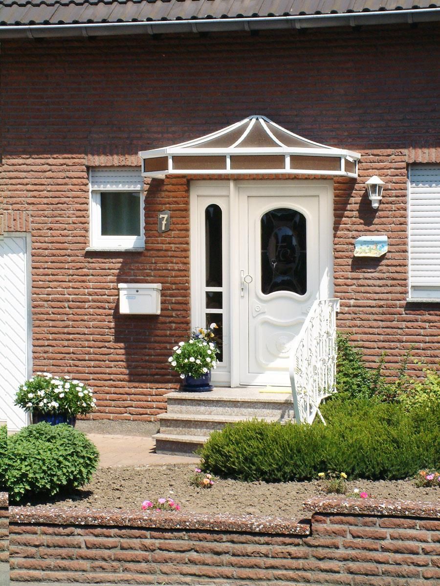 Ein rotes Backsteinhaus mit einer weißen Eingangstür
