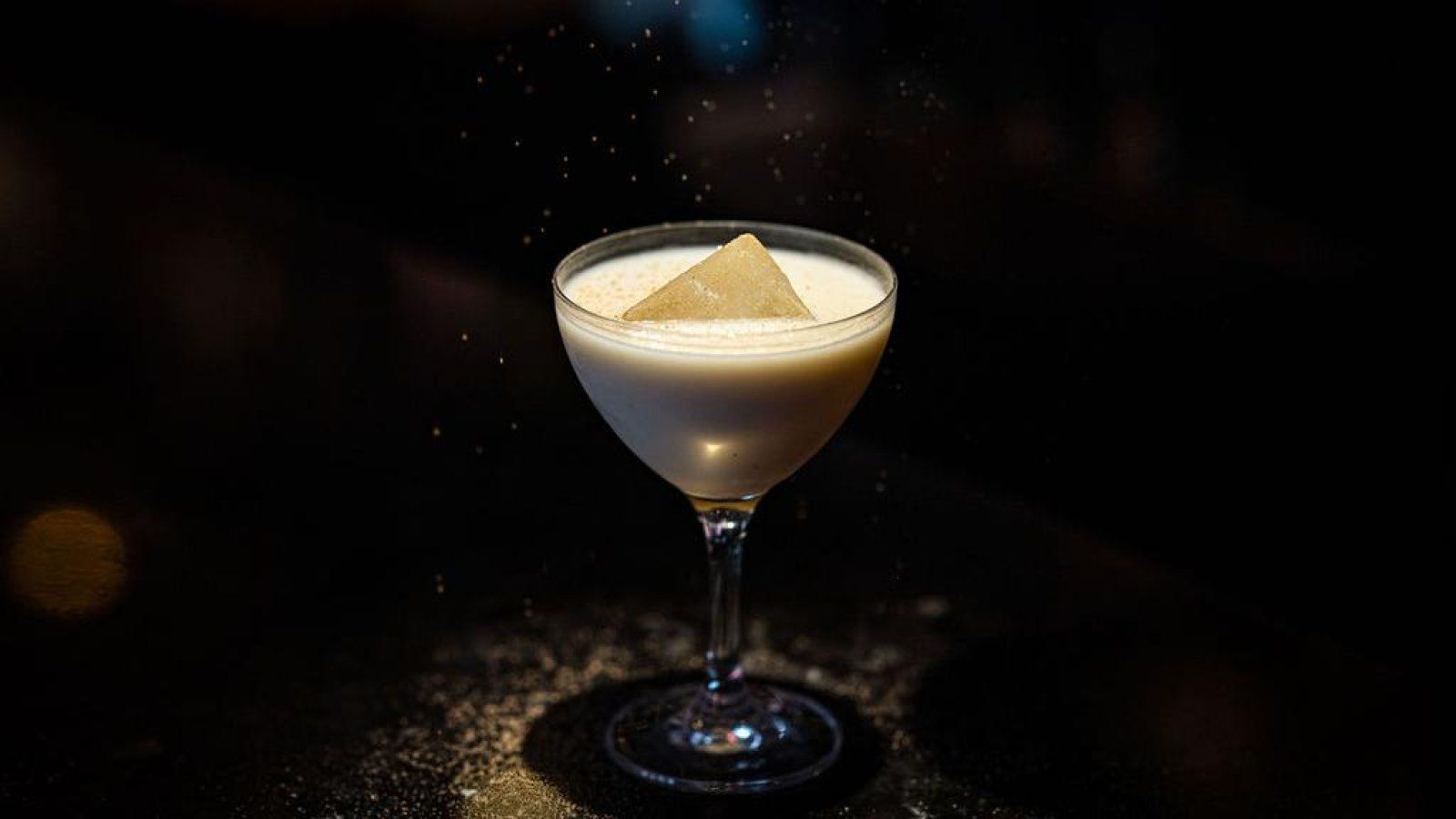 A close up of a cocktail in a martini glass on a table.