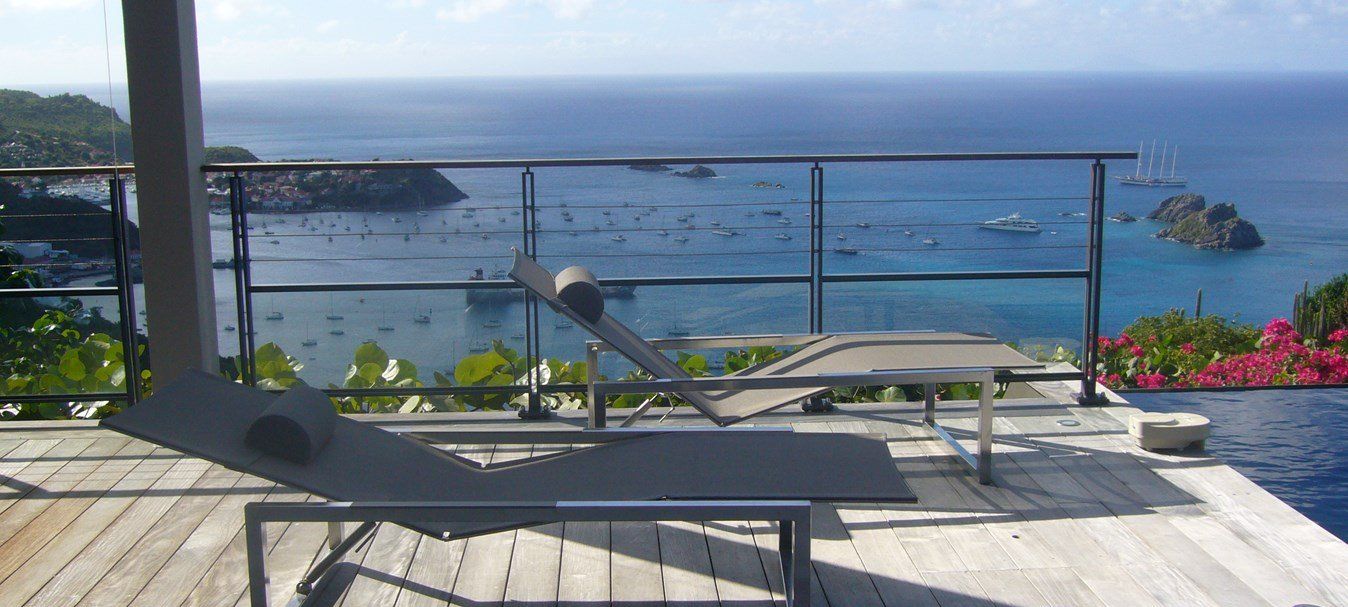 Un garde-corps le long d'une terrasse en bois avec vue sur la mer.