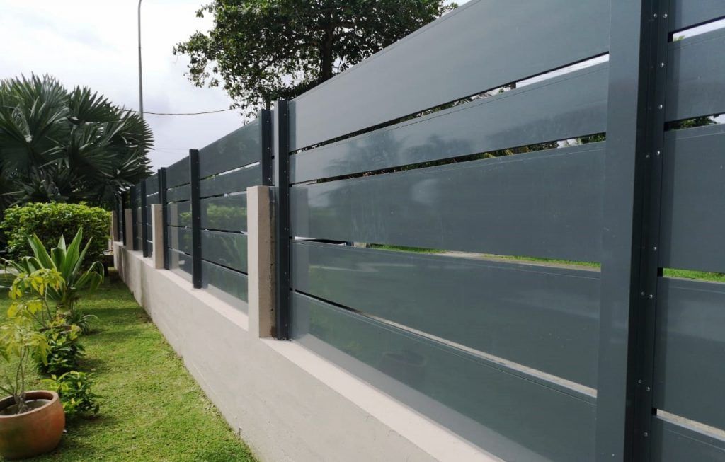 Une clôture avec des panneaux en aluminium.