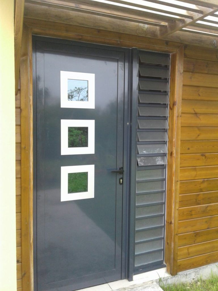 Une porte d'entrée en aluminium avec une jalousie de sécurité sur le côté.