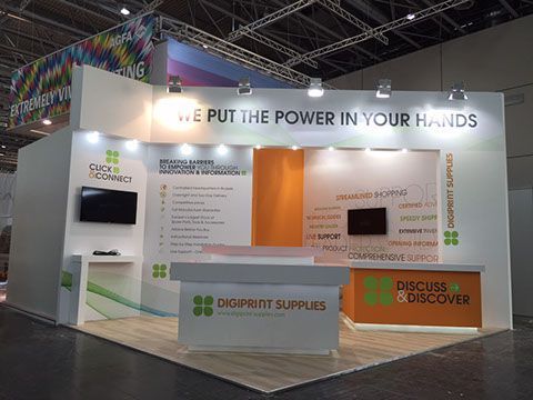 Stand de feria comercial con paredes blancas y naranjas, texto 