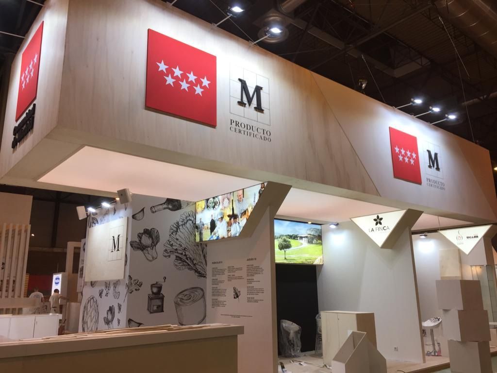 Stand de Madrid en una exposición. Rótulos rojos y blancos con estrellas y el logotipo de la 