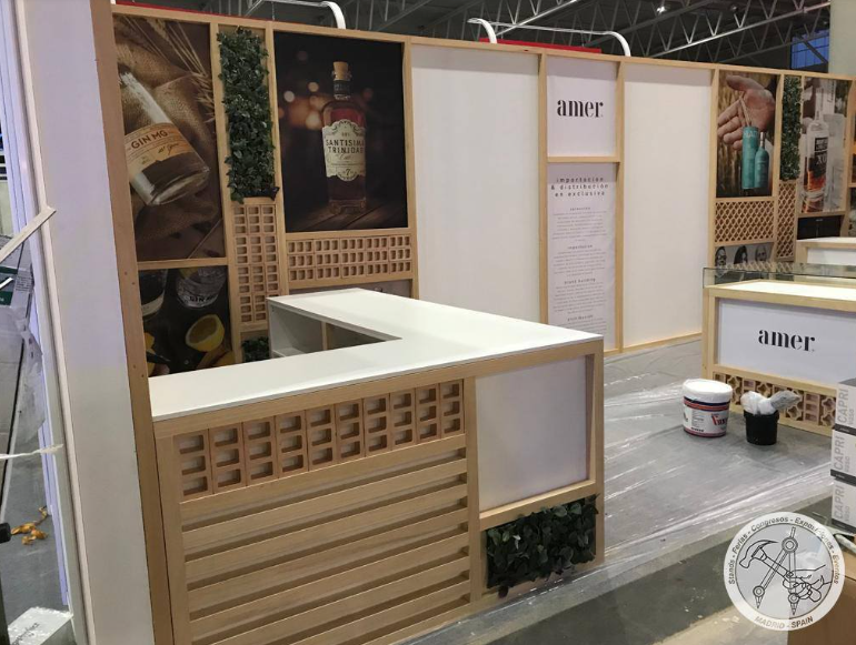 Stand de feria vacío con detalles de madera y exhibiciones de productos; mostrador blanco.