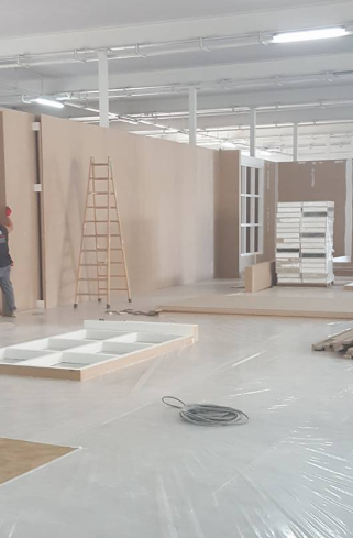 Obra: muros en construcción, escalera, materiales en el suelo. Hombre trabajando.