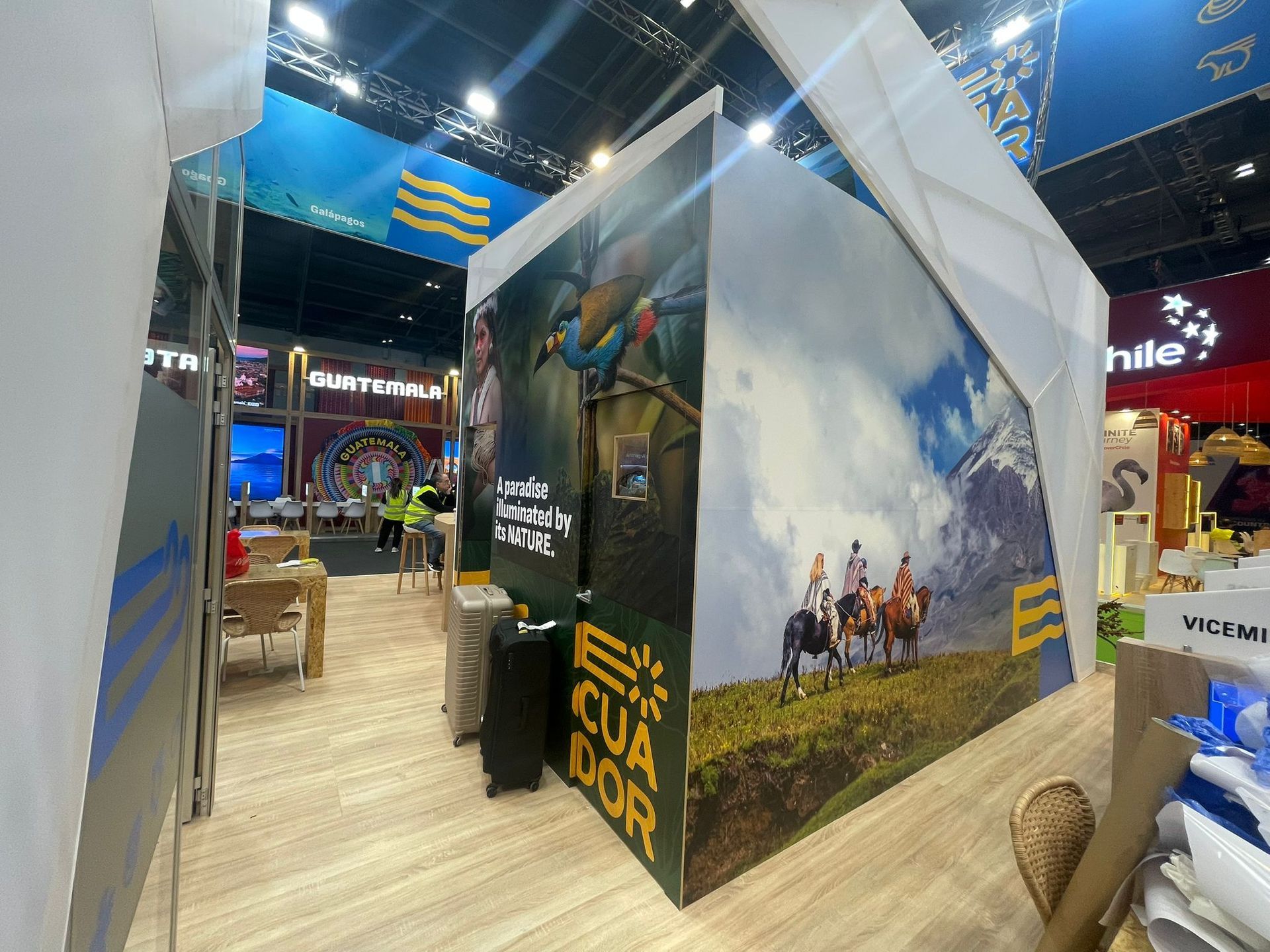 Stand de exposición de viajes de Ecuador con fotografías coloridas de los paisajes y la cultura del país.