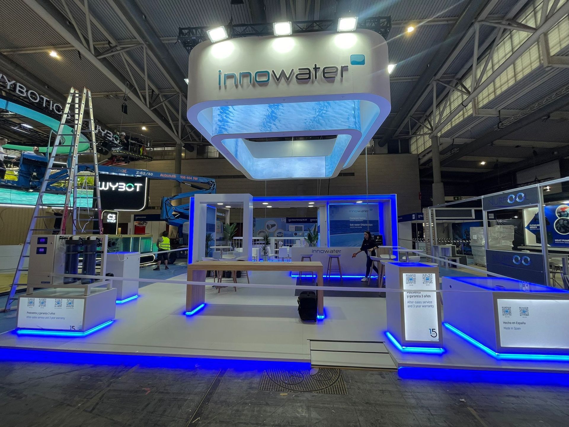 Un stand de Innowater en una feria comercial con luces azules y blancas, mostrando tecnología del agua.