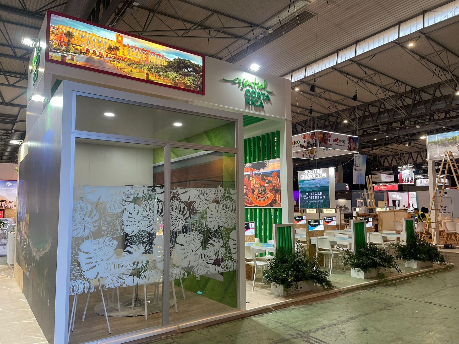 Stand de feria de turismo con diseño verde y blanco, mostrando imágenes de viajes.