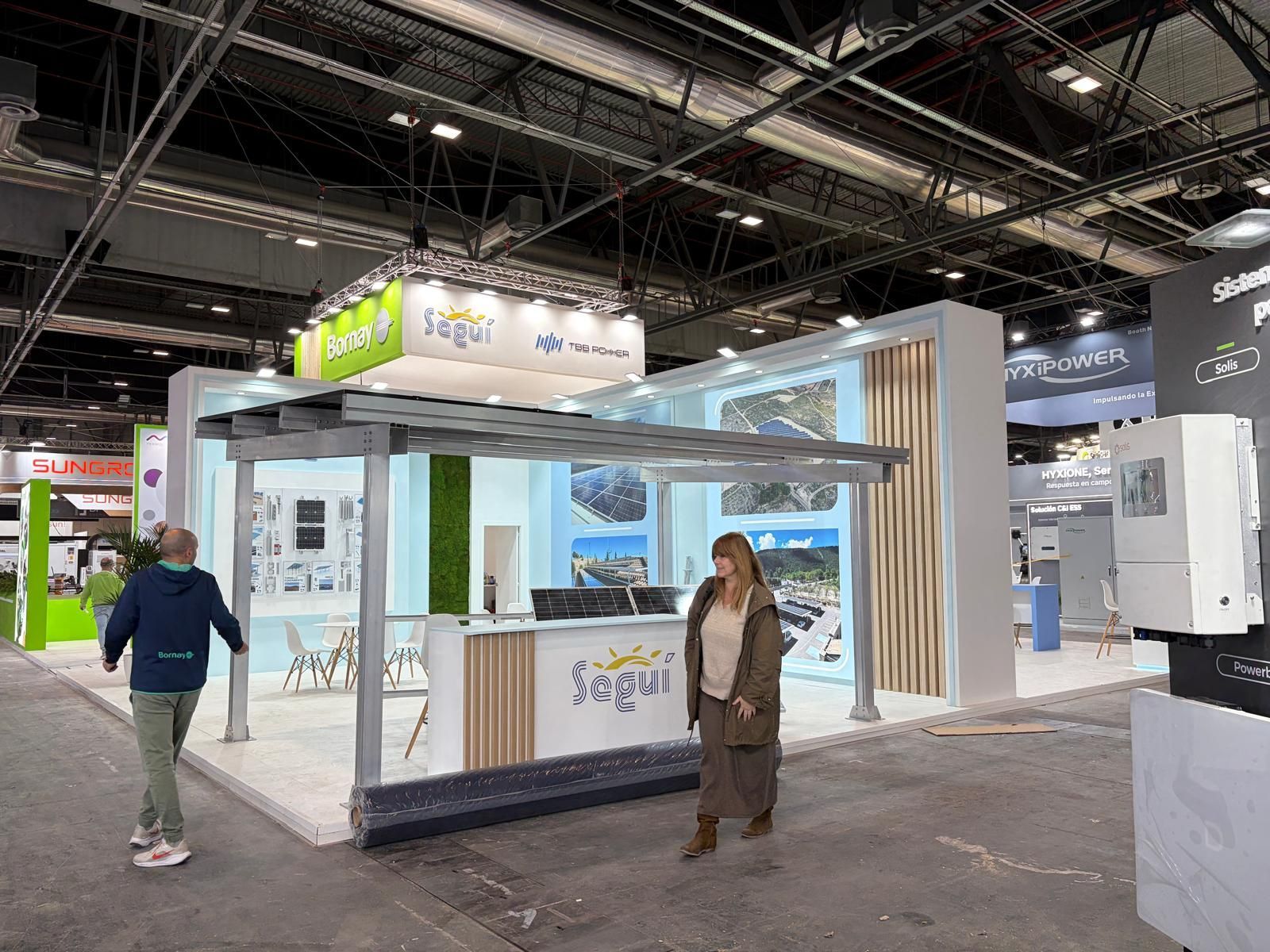 Personas en un stand de feria comercial con el cartel