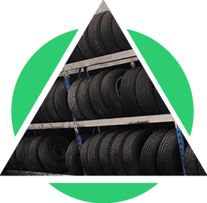 Des rangées de pneus empilés sur des étagères à l'intérieur d'un motif vert en triangle et en demi-cercle.
