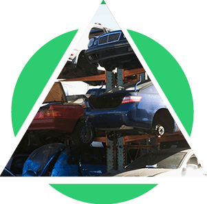 Voitures empilées dans une casse, partiellement encadrées par un triangle et un cercle verts.