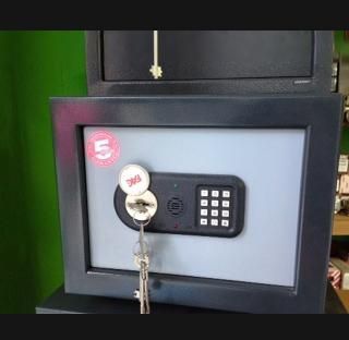 Una caja fuerte con una llave dentro está encima de una mesa.