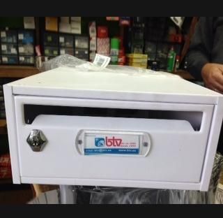 Un buzón blanco está sobre una mesa en una tienda.