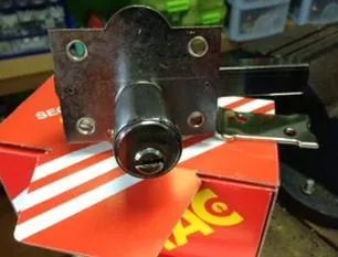 Un candado está encima de una caja roja y blanca.