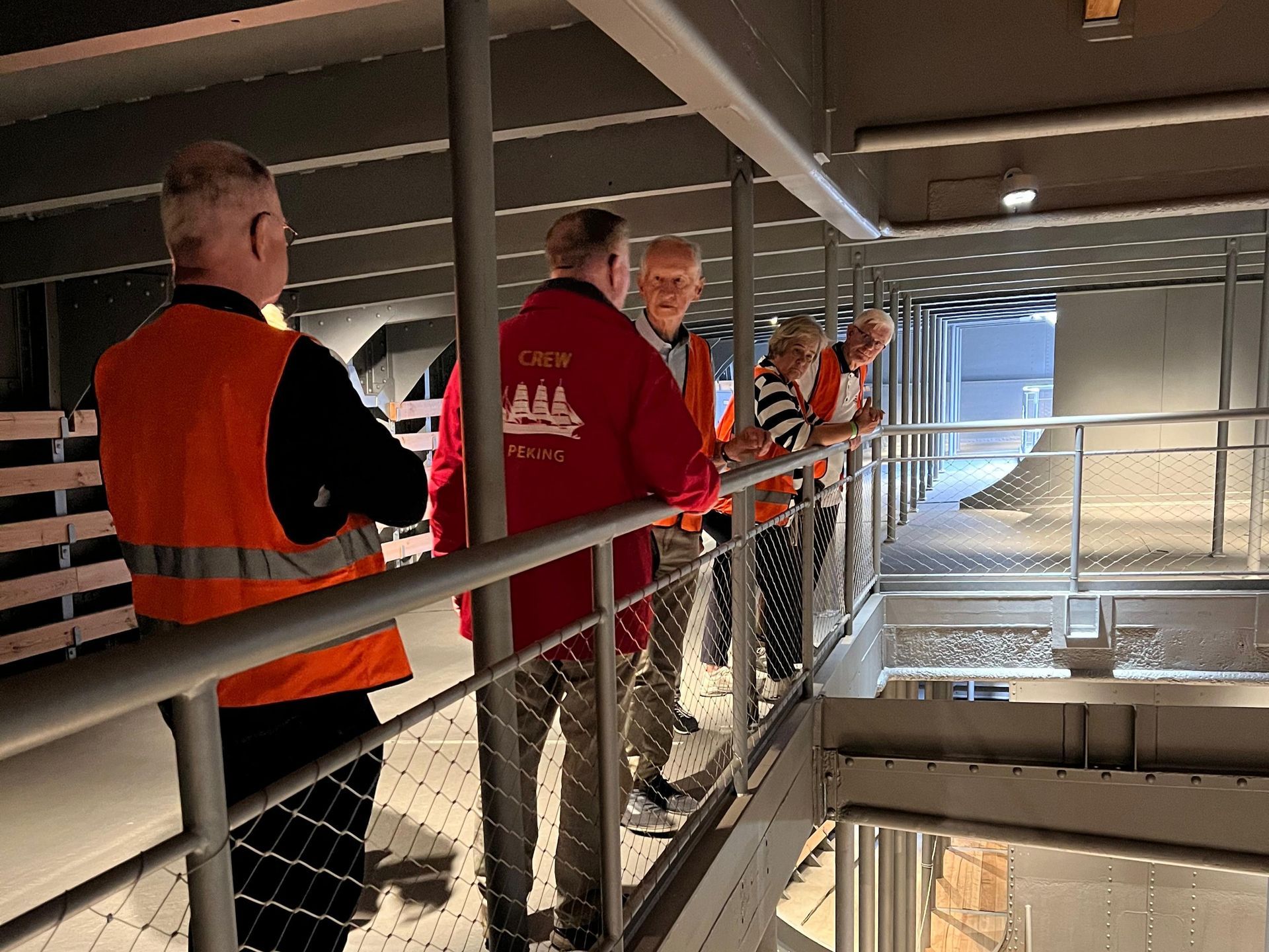 Eine Gruppe von Leuten besichtigt den Laderaum eines Segelschiffs