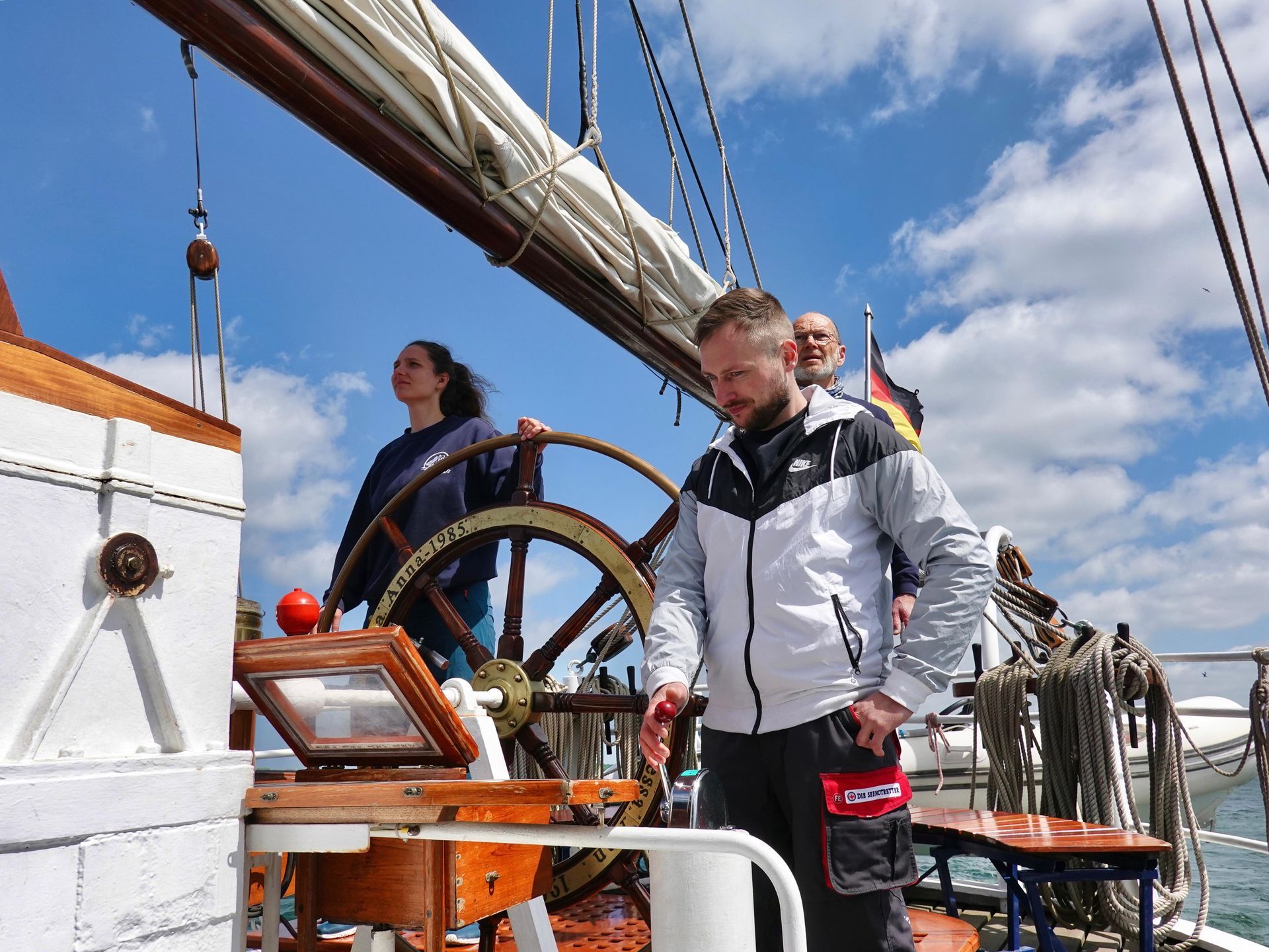 Eine Gruppe von Leuten steht hinter einem Steuerrad