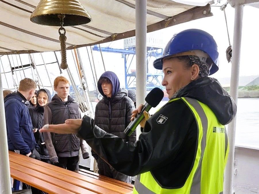 Mitarbeiter eines Hafenbetriebs an Bord eines Segelschiffs