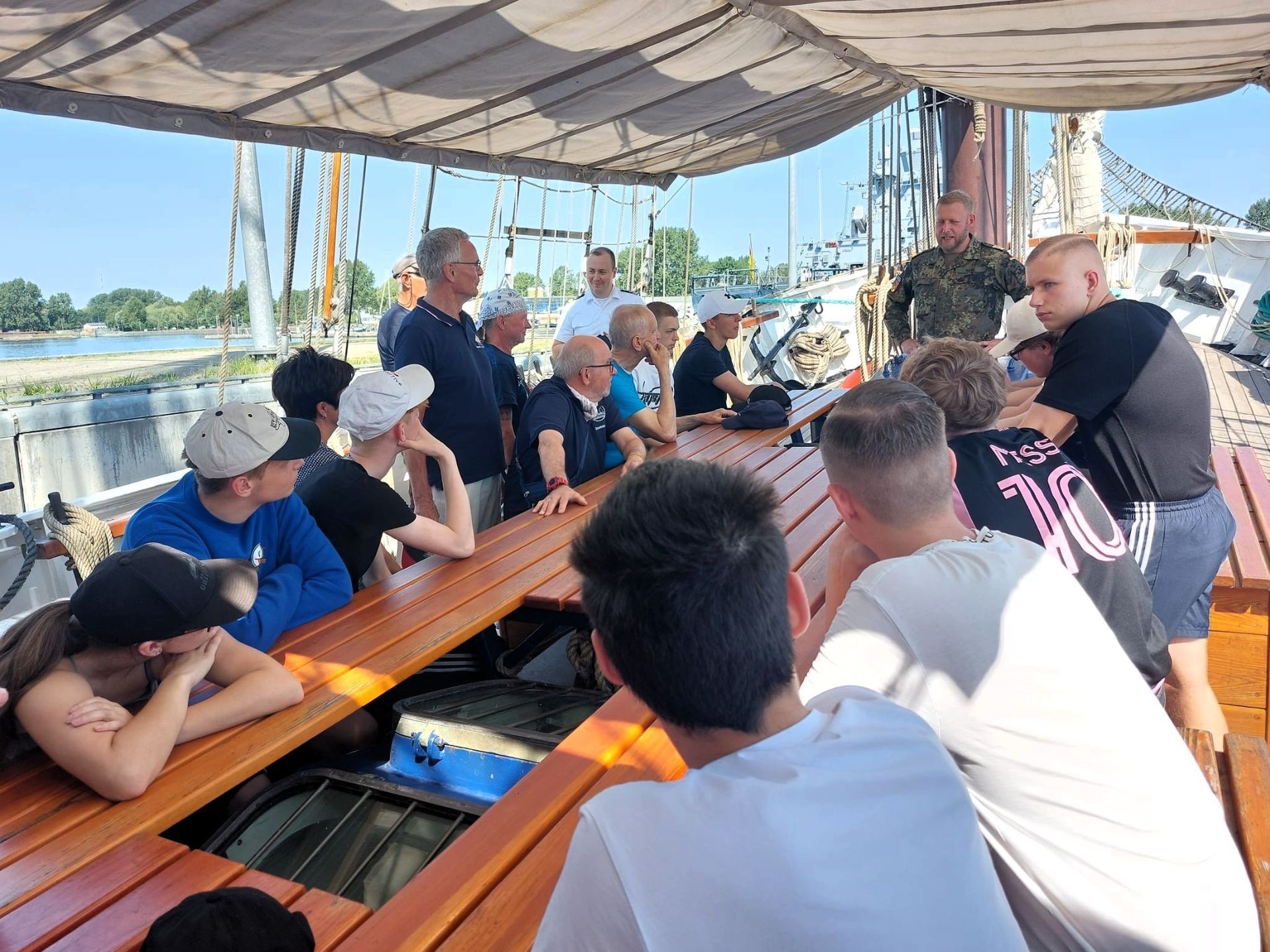 Marinesoldat erklärt einer Schulklasse seine Aufgaben auf einer Fregatte