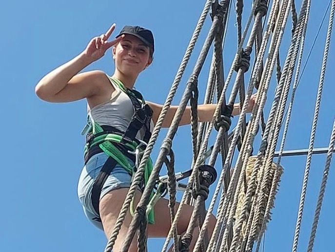 Eine Person klettert in die Masten eines Segelschiffes