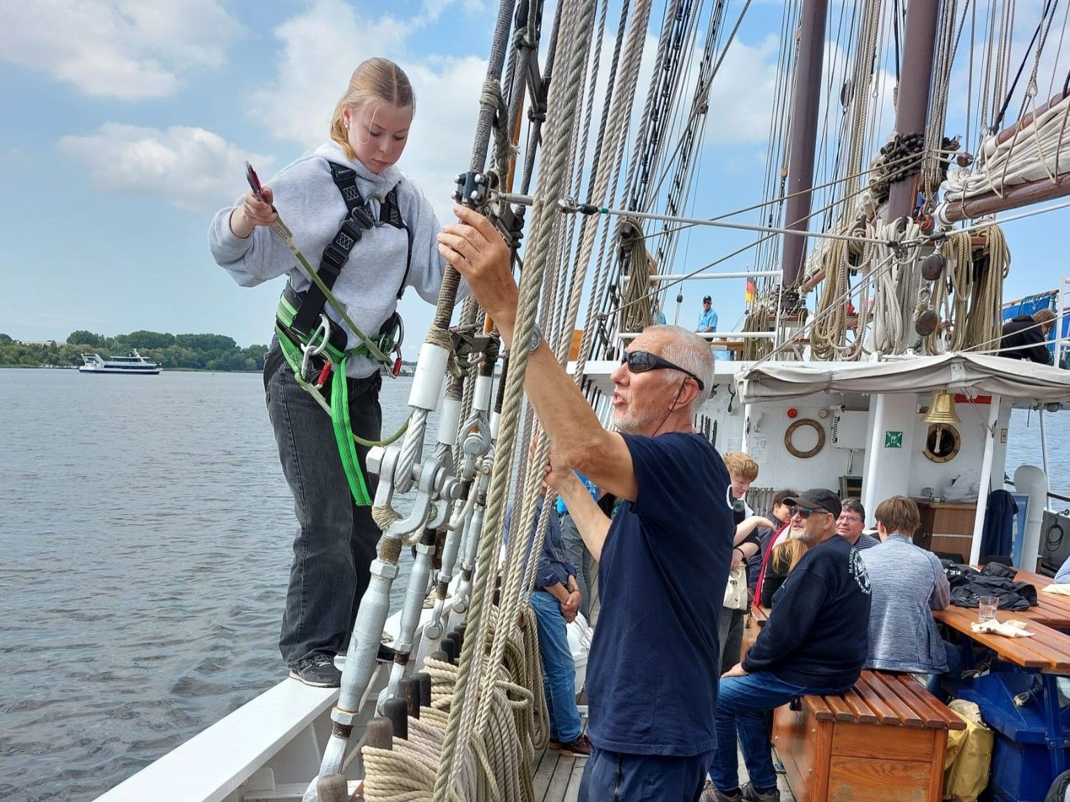 Eine Person klettert in die Saling eines Segelschiffs