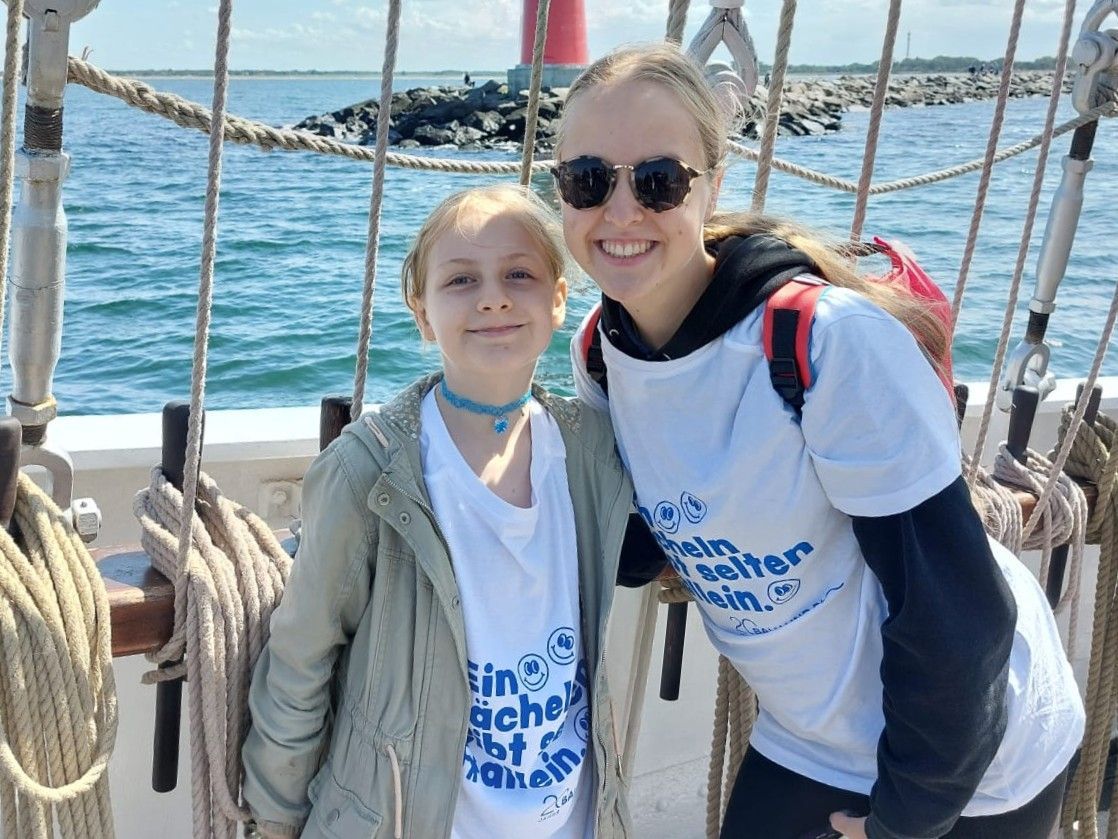 Zwei Personen stehen auf einem Segelschiff