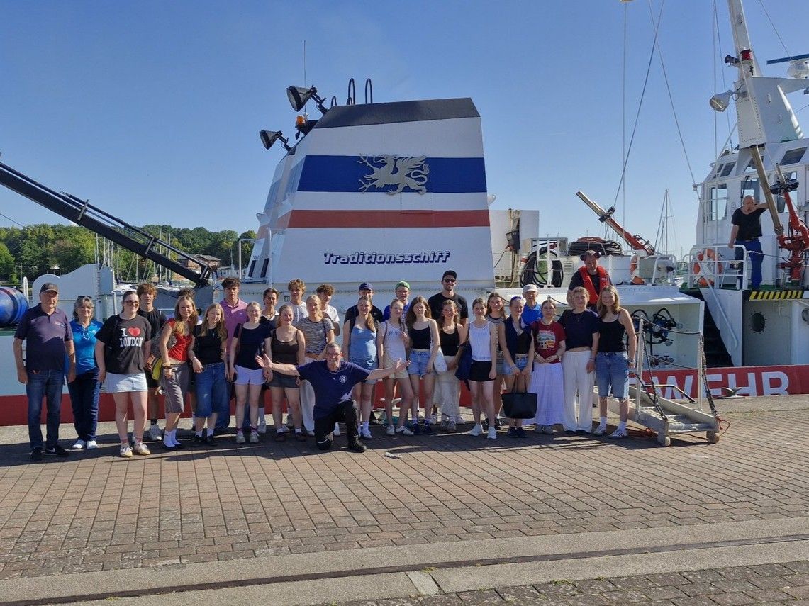 Eine Gruppe von Leuten steht vor einem Feuerlöschboot