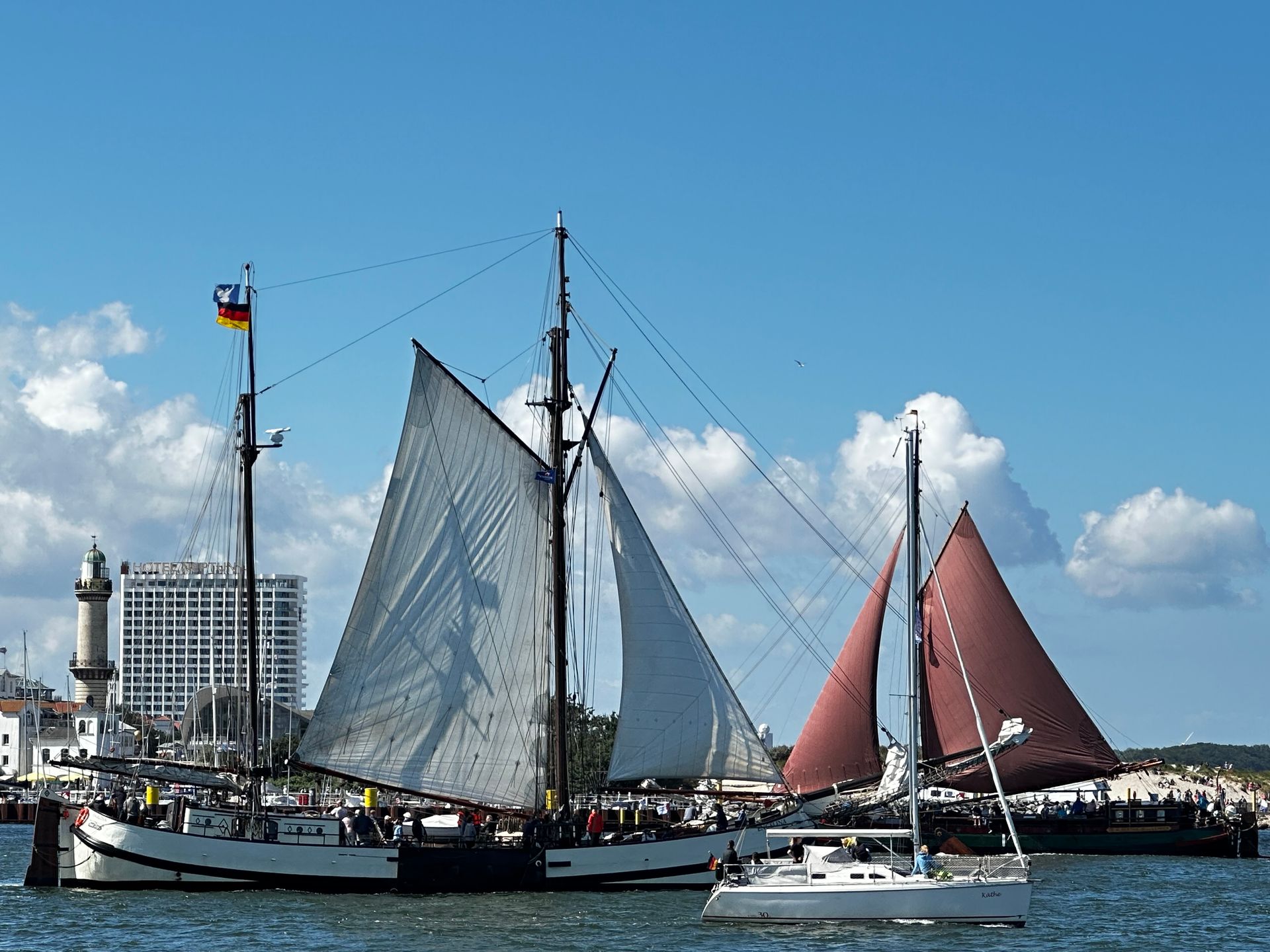Segelschiffe bei der Fahrt vorbei am Leuchtturm Warnemünde