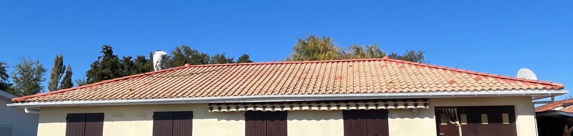 Gros plan de tuiles en terre cuite patinées, montrant l'âge et la texture avec une décoloration foncée.