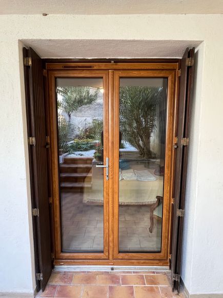 Menuiserie PVC couleur imitation Bois avec persiennes bois qui se rabat sur les cotés