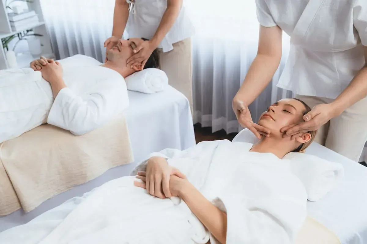 Un hombre y una mujer están recibiendo un masaje en un spa.