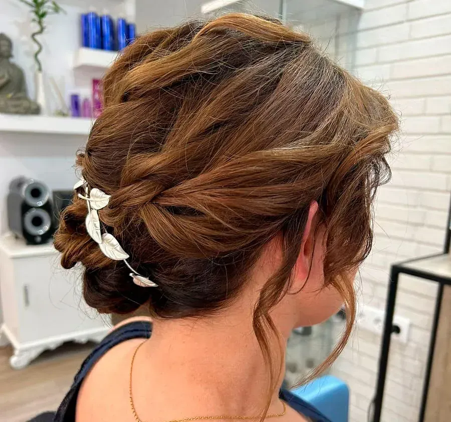 Una mujer lleva el pelo recogido en un moño con una flor en él.