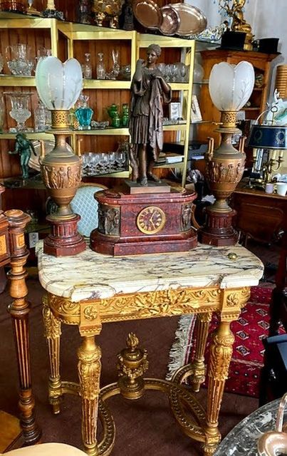 Table vintage ornée de lampes et d'antiquités décoratives.