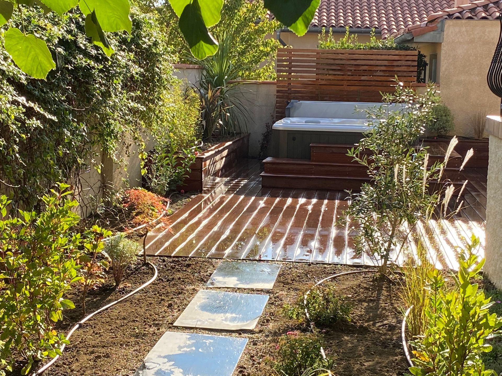 Photo d'un jardin aménagé avec un jacuzzi et une terrasse en bois.