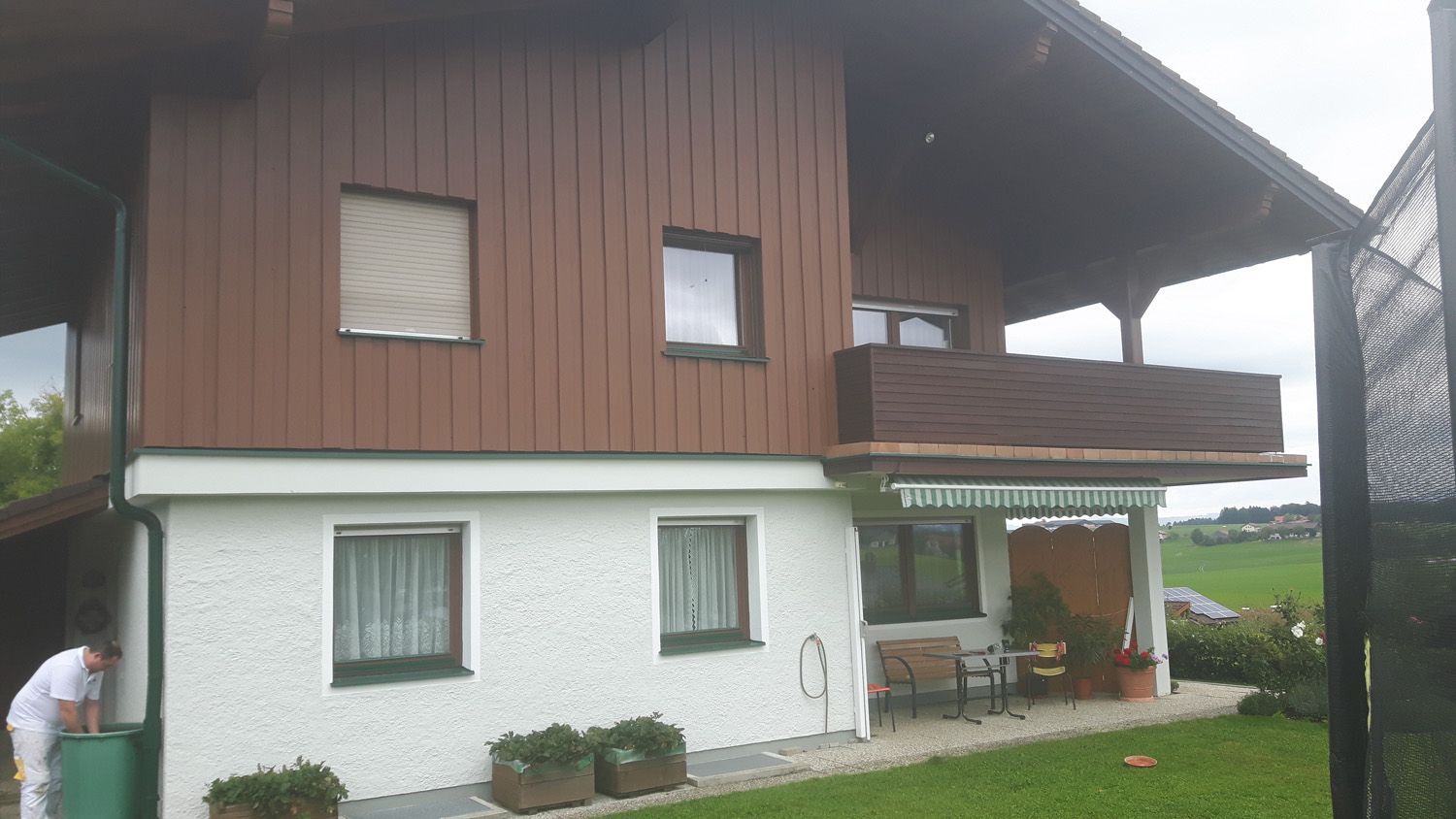 Ein Mann steht vor einem Haus mit Balkon.