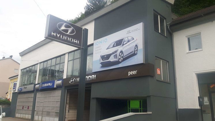 Ein Hyundai-Autohaus mit einer großen Werbetafel an der Seite des Gebäudes.