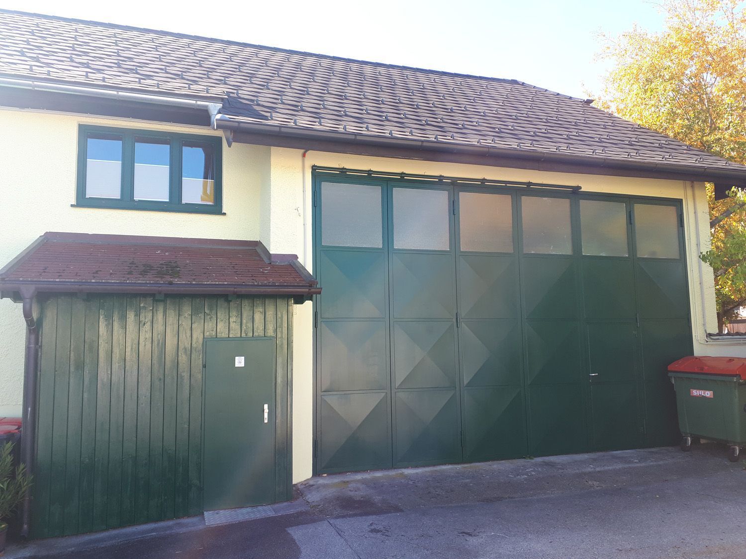 Ein Haus mit einem großen grünen Garagentor