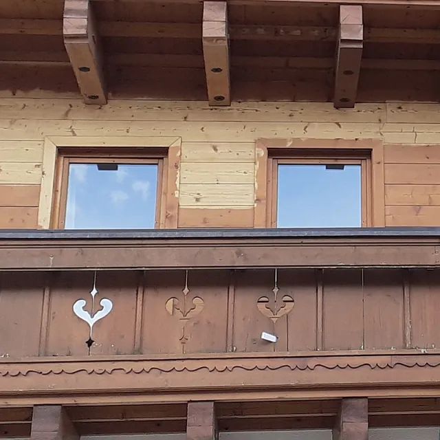 Ein Holzgebäude mit einem Balkon und zwei Fenstern