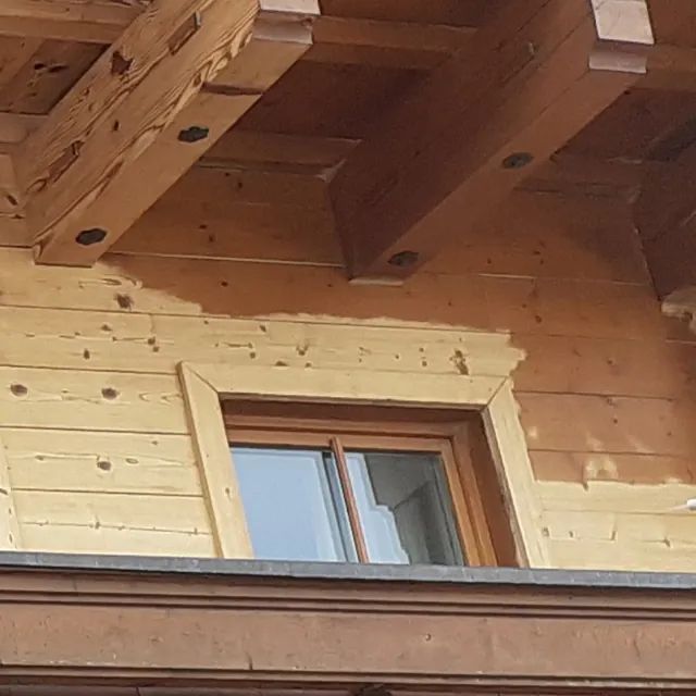 Ein Holzgebäude mit einem Fenster und einem Holzdach.