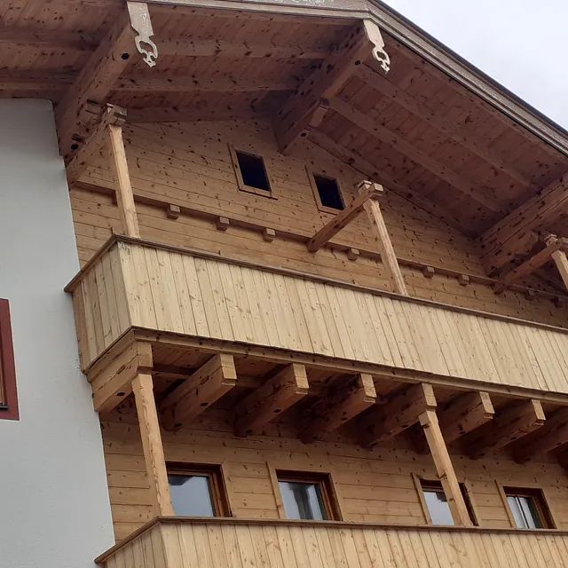 Ein großes Holzgebäude mit Balkon und Dach