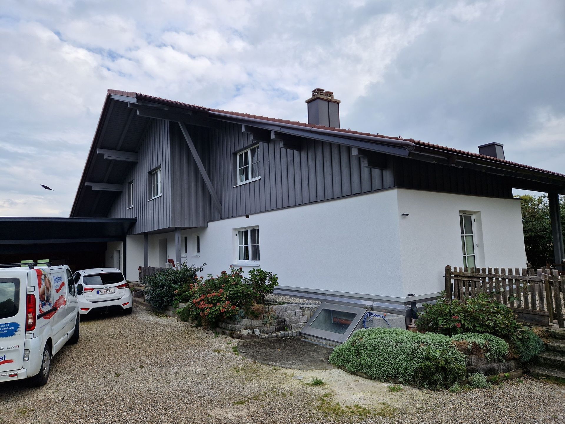 Ein weißer Lieferwagen parkt vor einem großen Haus.