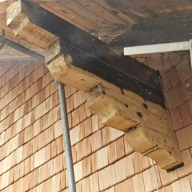 Ein Holzbalken ist an der Seite eines Gebäudes befestigt