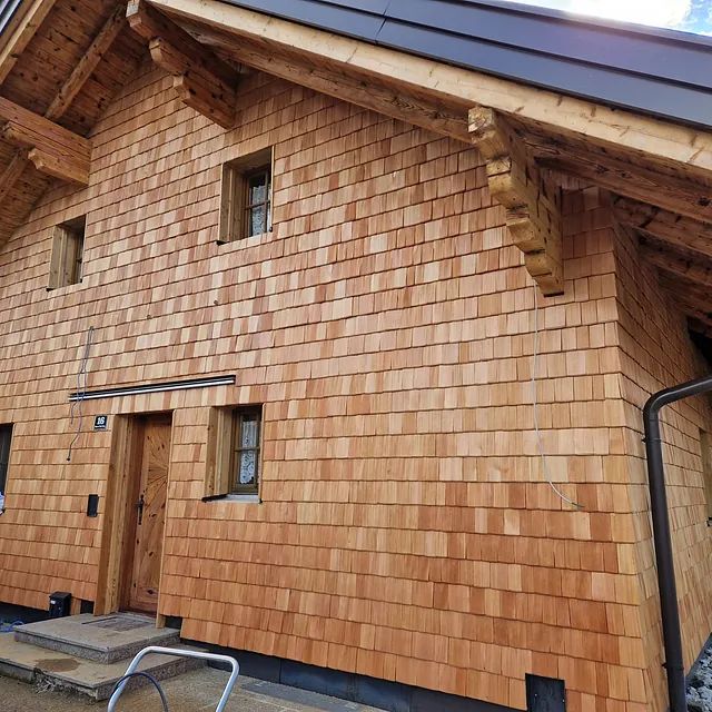 Ein großes Holzhaus mit einem schwarzen Dach