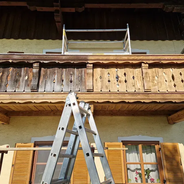 Eine Leiter lehnt an einem Holzbalkon