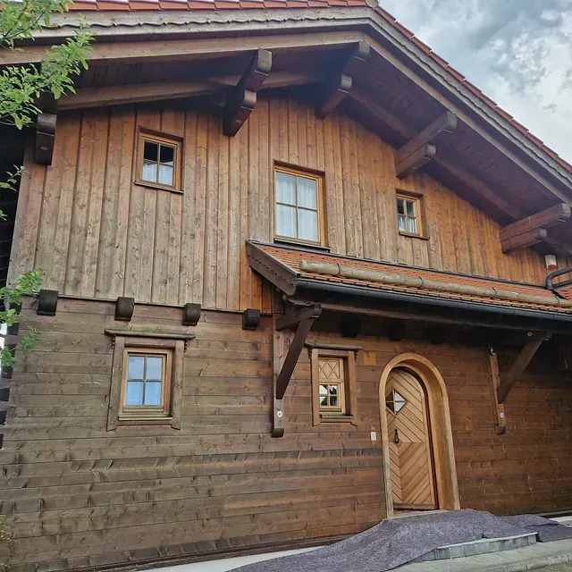 Ein großes Holzhaus mit gewölbten Türen und Fenstern