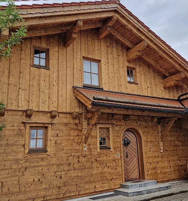 Ein großes Holzhaus mit einem roten Ziegeldach