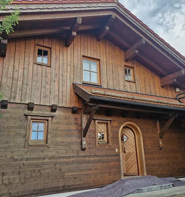 Ein großes Holzhaus mit gewölbten Türen und Fenstern