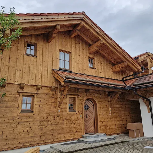 Ein großes Holzhaus mit einem roten Ziegeldach