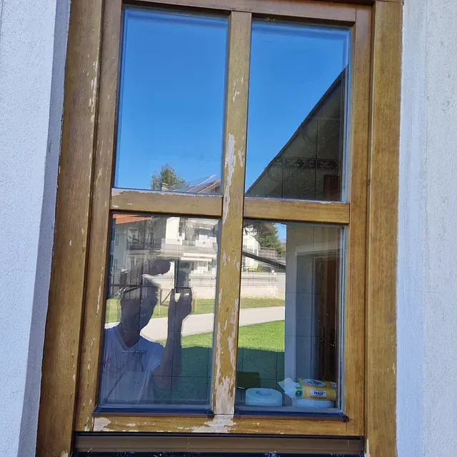 Ein Mann macht ein Foto von sich selbst in einem Fenster.