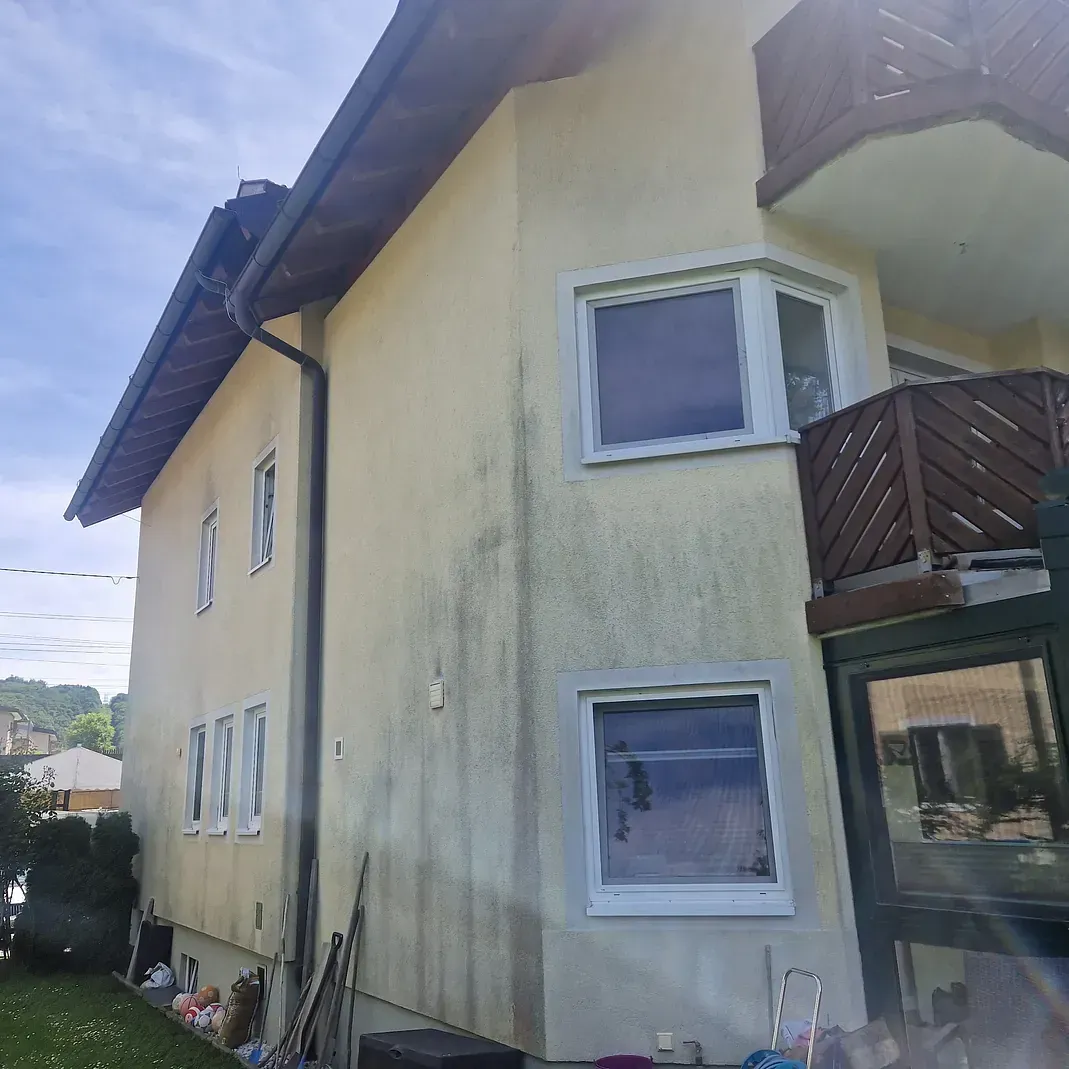 Ein großes Haus mit Balkon und vielen Fenstern